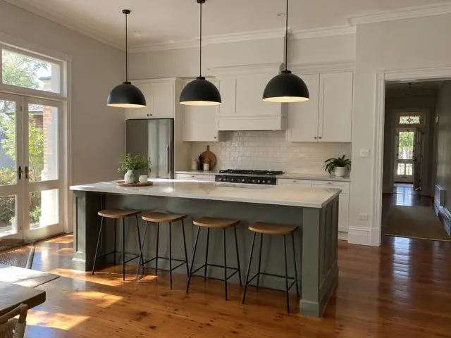 Three black pendant lights over a kitchen island in a modern kitchen in Normanhurst
