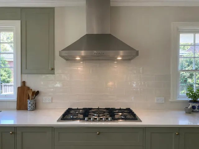 Stainless steel range hood above a gas cooktop in a kitchen with tiled splashback in Wahroonga